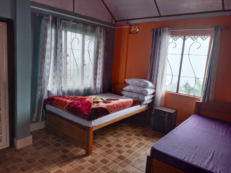 Cozy homestay room in Sittong: warm tones, wooden decor, mountain view, inviting ambiance, serene getaway.