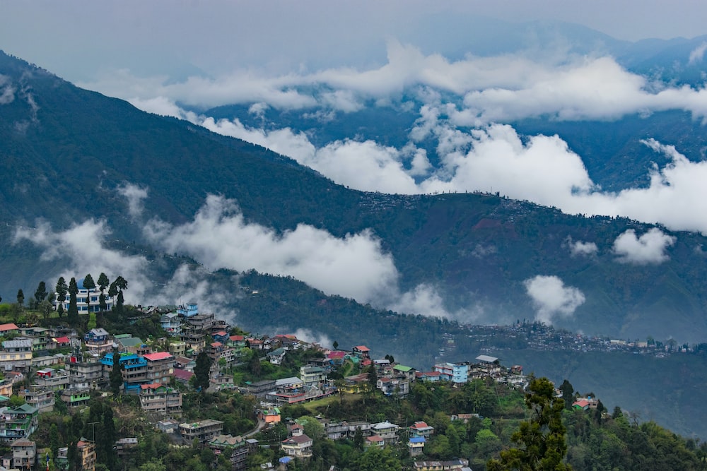 A panoramic view of the majestic Himalayan mountain range from Darjeeling, showcasing snow-capped peaks, valleys, and lush greenery."